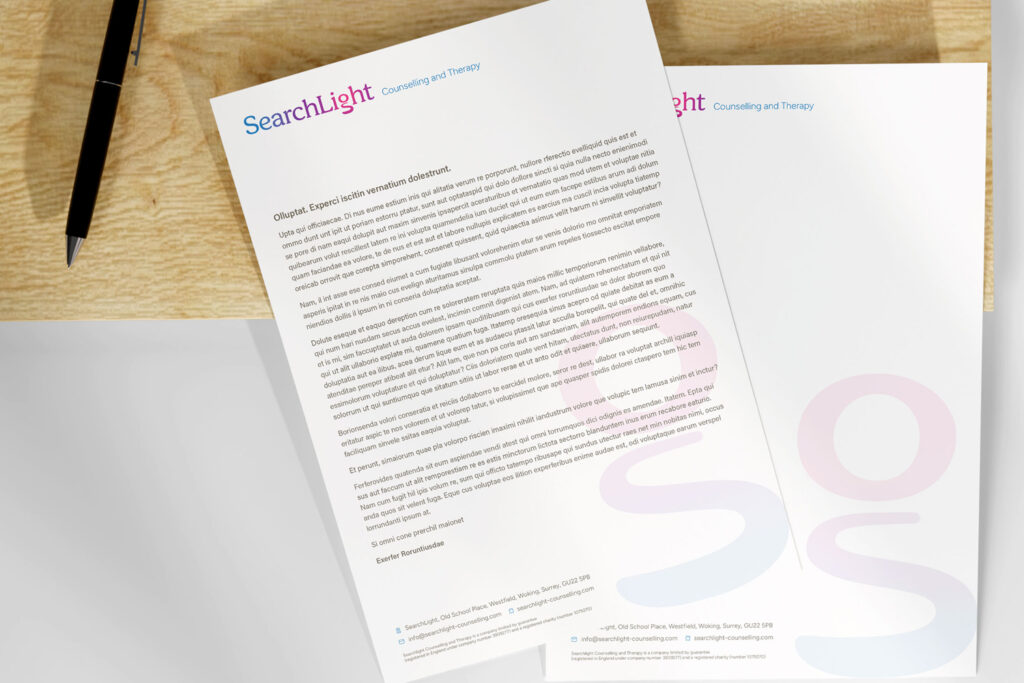 SearchLight letterheads and pen on a desk